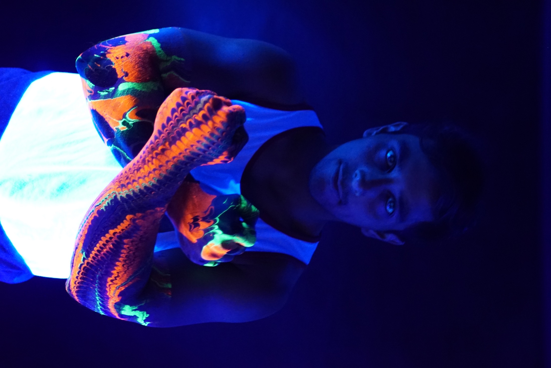 Figure with fluorescent Ebru-painted arms