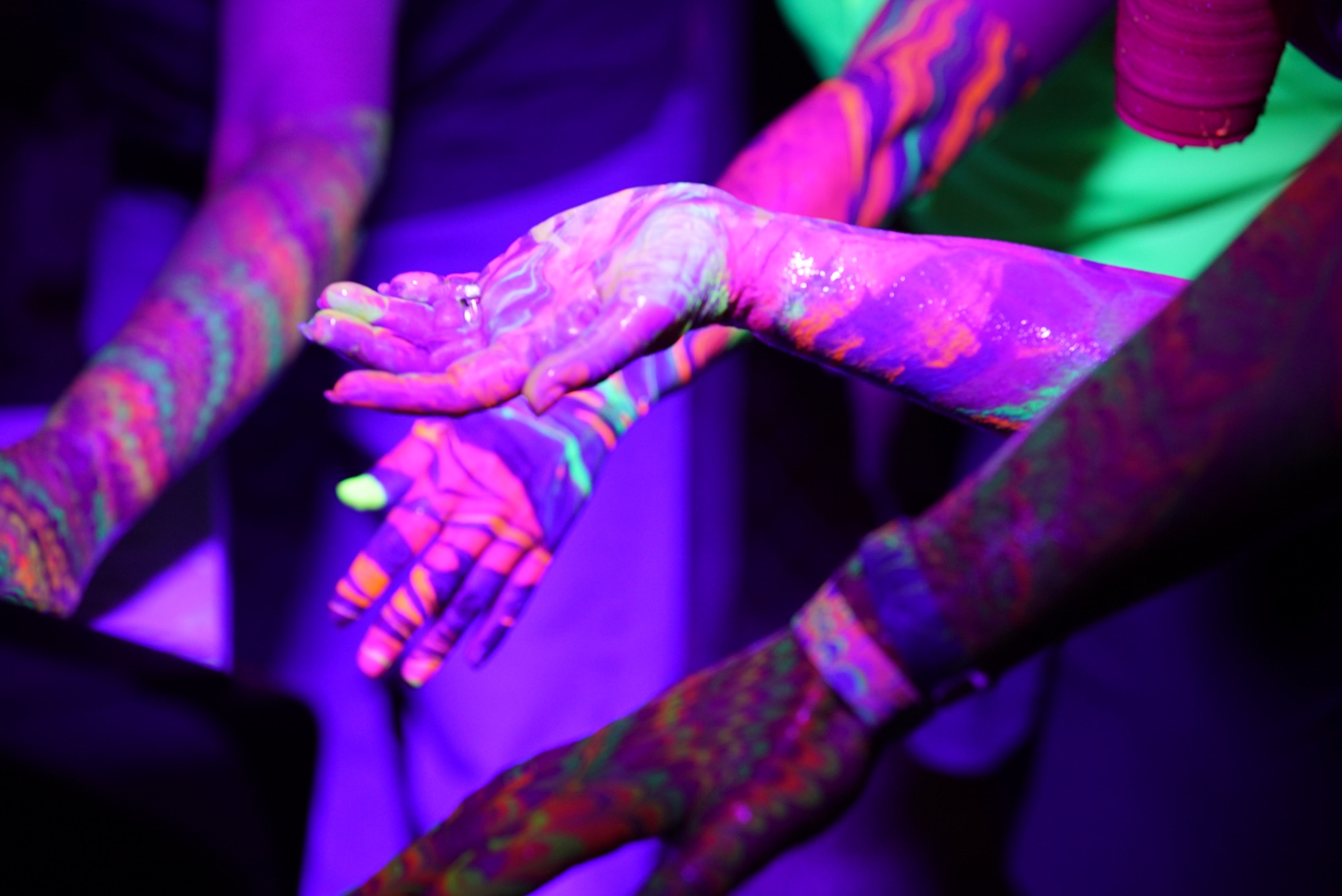 Fluorescent Ebru marbling over hands and arms